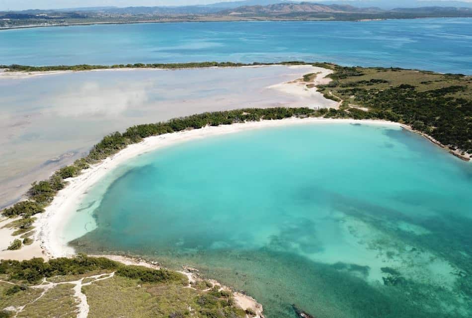 Aerial view of a beach with different bodies of water surrounded by sand and green vegetation