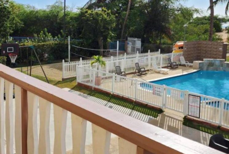 View of the pool, basketball court, volleyball court, and patio area from second level of the property